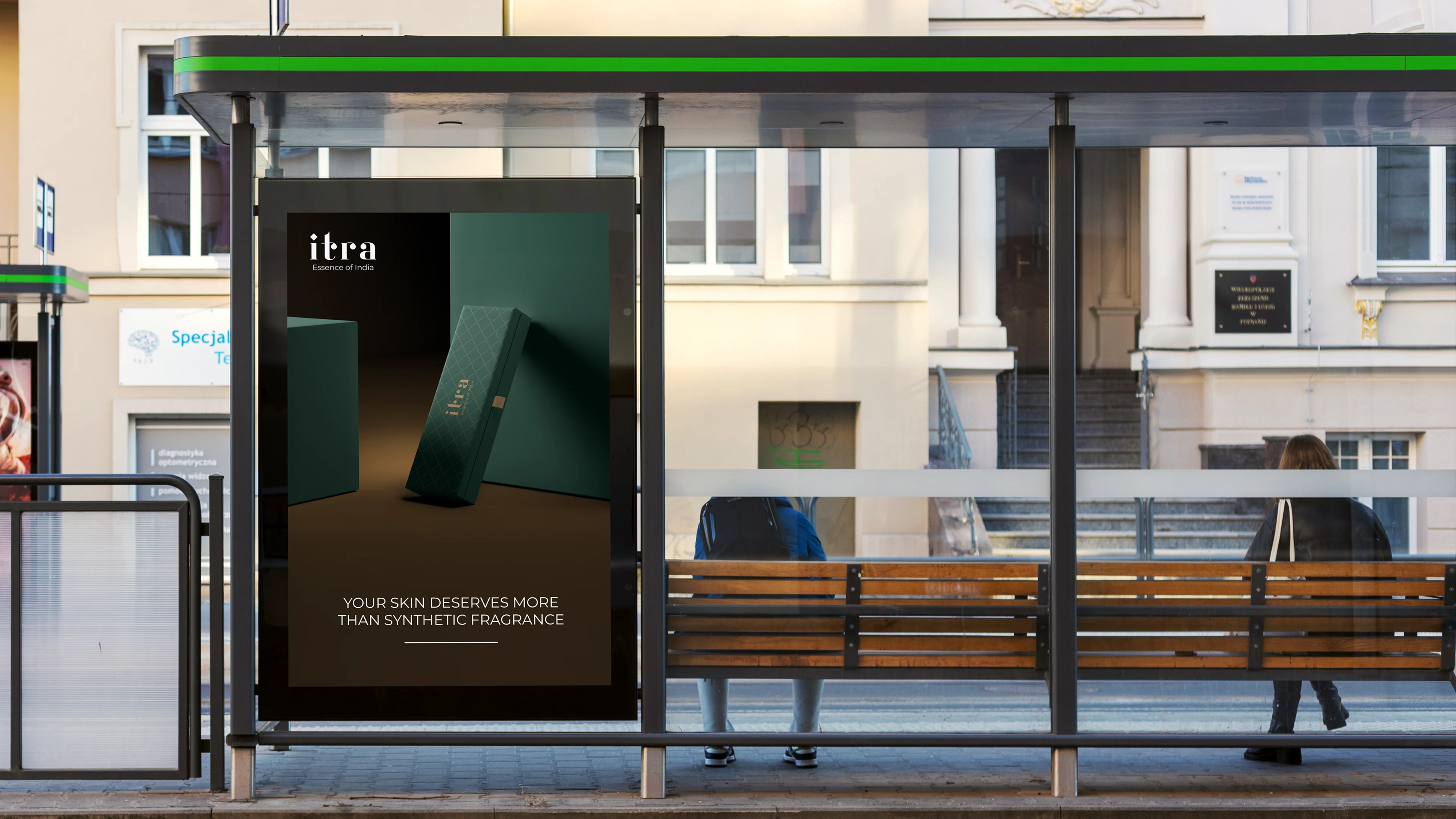 Itra OOH poster on a backlit bus shelter display, showing a dramatically lit product box against a dark background